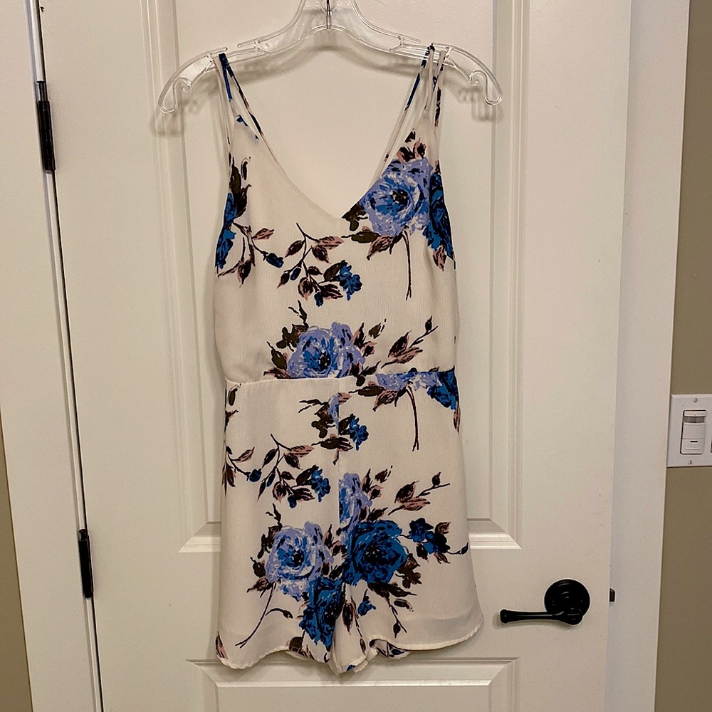 White romper with blue flowers throughout. Super light and comfortable.